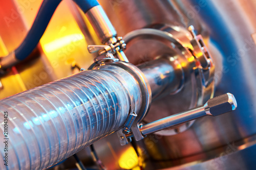 Close up connecting clear hose to industrial machinery