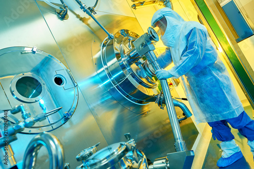 Scientist working with bioreactor in pharmaceutical cleanroom