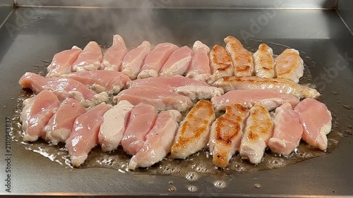 Grilled Chicken Strips Cooking Batch On Flat-Top Surface Sizzling Golden Brown For Culinary Food Preparation Video
