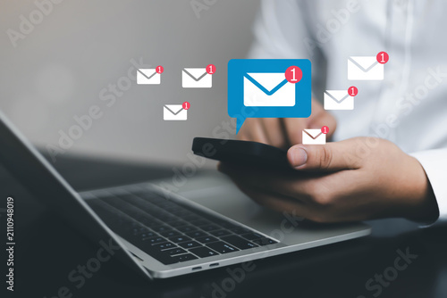 Картината върху платно Business professional using smartphone with email notification icons above lapto