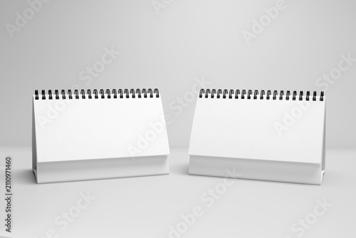 Desk calendar mockup set with two standing blank white horizontal table calendars, flip wire binder template side by side on grey background, front view presentation, 3d render