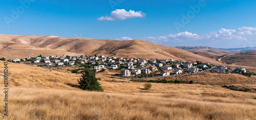 In the arid Judean Desert hills, a vibrant Israeli settlement thrives with a blend of secular and religious residents.