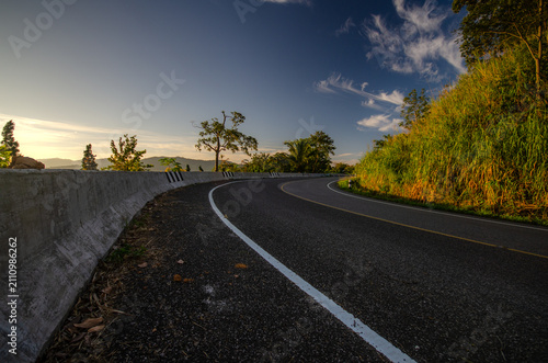 A winding road with a blue sky in the background.