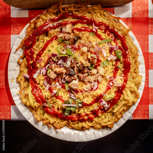 Fried rice garnished with ketchup, chopped onions, and green onions on