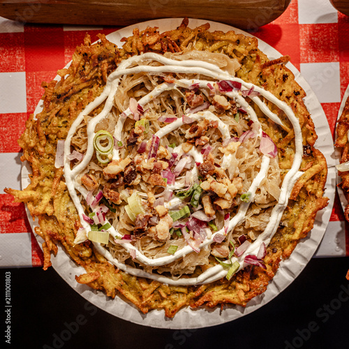 Crispy latke with shredded cabbage, red onions, and white sauce on pap