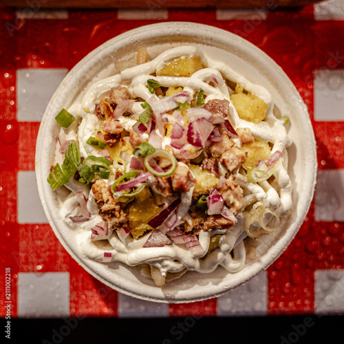 Bowl of food with creamy sauce, onions, and lettuce garnish