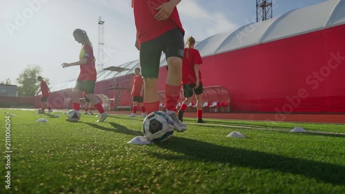 Dynamic womens soccer training session on artificial turf with coordinated dribbling drills, cones, and teamwork in bright daylight practice environment