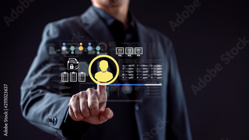 ISO certification quality management and compliance audit standard concept. Businessman touching virtual person icon with ISO badges, checklists and secure document icons on dark background.