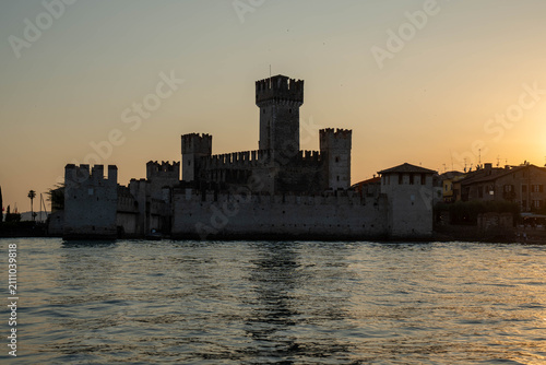 Sunset over Scaliger Castle in Sirmione view from boat on Lake Garda, Italy