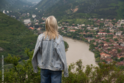 Fotografía Woman standing on a hill admiring the panoramic landscape view of Mtskheta town,