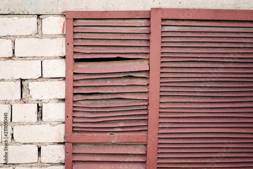 Bild auf Leinwand Damaged metal ventilation louver grill mounted on white brick wall