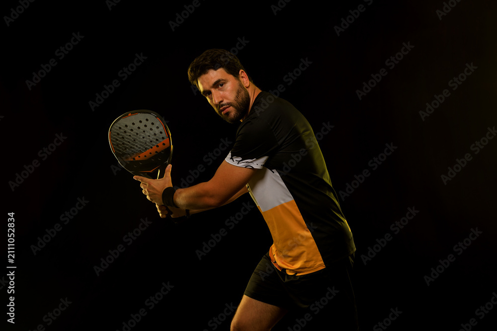 Fototapeta premium Padel Tennis Player with Racket in Hand. Paddle tenis, on a blue background. Download in high resolution.