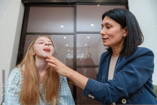 фотографія Smiling female speech therapist uses laptop computer for teaching