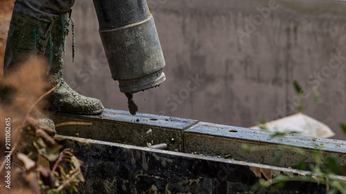 Concrete Pump Hose Filling House Foundation at Construction Site