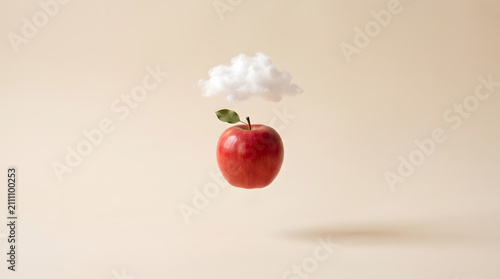 A surreal red apple floating in the air with a small white cloud against a neutral background. AI generated.