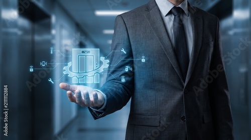 Businessman holding holographic elevator icon. Corporate manager using digital lift interface.