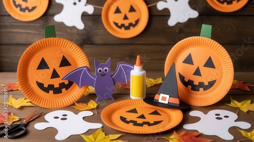 Handmade Halloween paper crafts on a wood table. DIY holiday decor ideas.