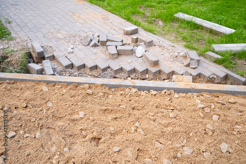 Cuadro en lienzo A section of pavement is damaged and uneven with scattered bricks