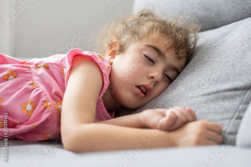 Canvas Print Sleeping little girl resting on sofa at home