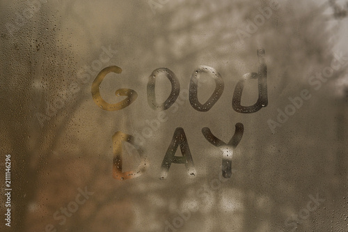 Fotografie Inscription Good Day is handwritten on fogged window glass with water drops