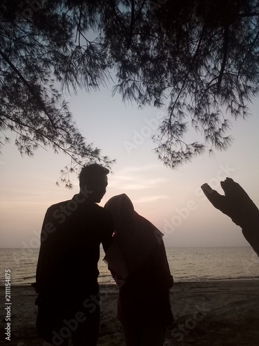silhouette of couple on the beach at sunset