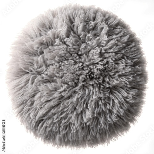 Round fluffy grey sheepskin faux fur pillow cushion with long shaggy curly wool texture.
