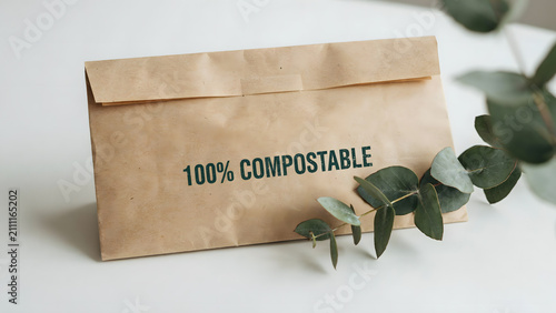 A brown paper envelope labeled as one hundred percent compostable with foliage