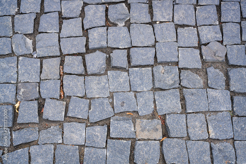Photography A close-up view of a fragment of a cobblestone pavement with cubic stones