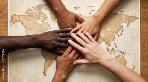 Diverse hands joined over a vintage style world map.