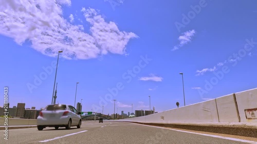ダイナミックな青空と白い雲が広がる高速道路の風景