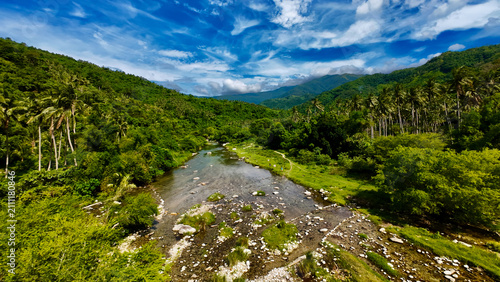 Obraz na plátne Mountain river winds through a lush tropical valley