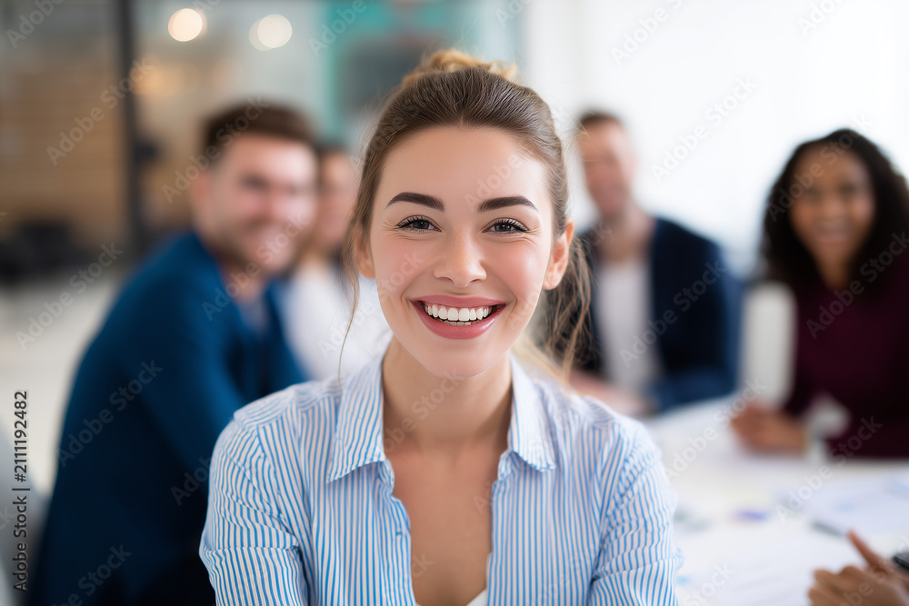 Obraz premium Portrait of happy smiling confident young very attractive businesswoman CEO professional manager entrepreneur in a skirt in a business meeting teamwork looking at camera