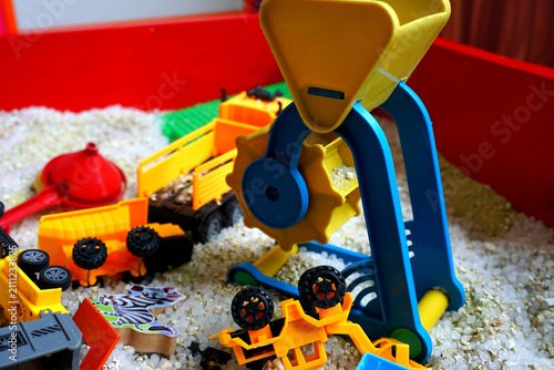 Foto Colorful toy construction vehicles playing in sandbox sandpit