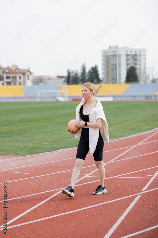 Obraz premium Blonde woman enjoys an outdoor workout on the stadium running track