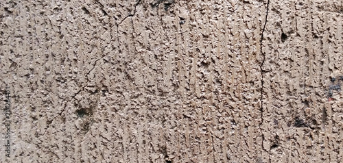 The texture of the concrete wall is rough and cracked.