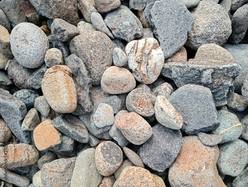 Canvas Print Close-up top view of mixed grey and brown river stones and smooth pebbles, natural texture background