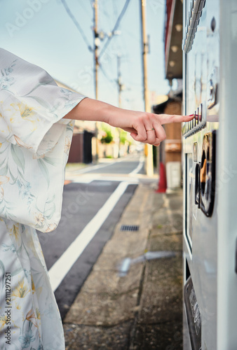 Фотография Woman wearing yukata using a vending machine in Japan