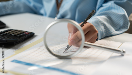 Foto Examining documents with a magnifying glass, highlighting tax records, real estate paperwork, investment research, application forms, document verification, and due diligence
