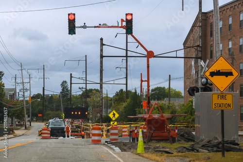 Workers manage traffic equipment for road repairs close to fire station,