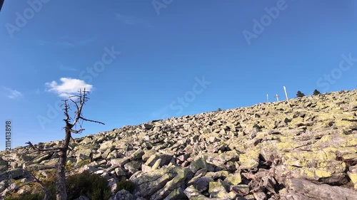Pan across the granite boulder field and summit cross of Mount Lusen in the Bavarian Forest on a clear summer day