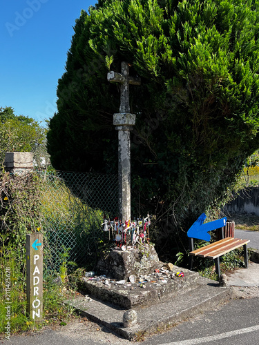 Stone cross and Padrón signpost on Camino de Santiago route in Spain