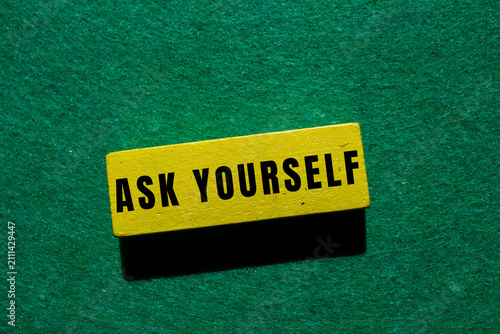 Canvas Print Yellow wooden block displaying ask yourself text on a vibrant green background,