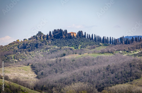 Fotografie Tuscan villa on hilltop with cypress trees in Siena countryside