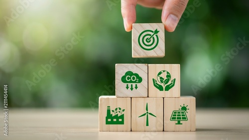 Bild auf Leinwand Hand stacking wooden blocks with environmental icons for sustainable development