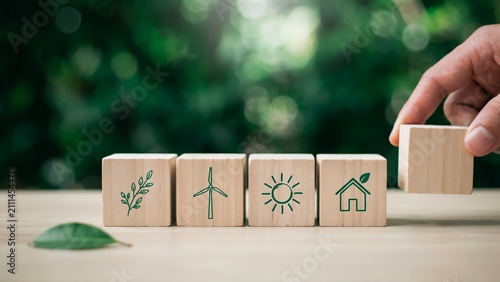 Canvas Print Hand placing wooden block with ecofriendly icons for sustainable development