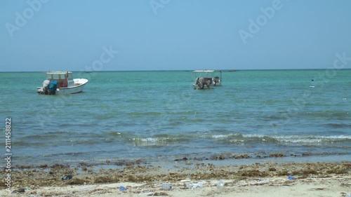 Fishing boats anchored at a dirty beach on a windy day
