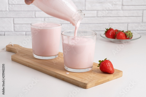 Cuadro en lienzo Pouring homemade fruit kefir, buttermilk or yogurt with probiotics