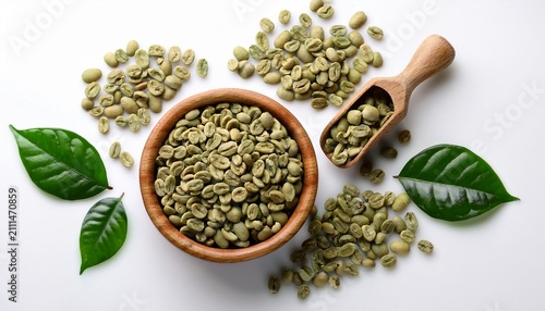 Overhead Shot On White Background Of Unroasted Green Coffee Beans Shallow Wooden Bowl Overflowing In Lower Right Wooden Scoop Upper Left Scattered Beans And Green Leaves