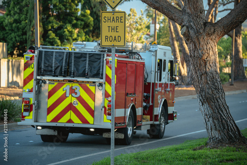 Canvastavla Fire truck with reflective stripes drives down a tree-lined street