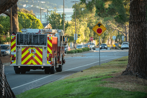 Konstfotografi Fire engine with reflective stripes drives down a suburban street